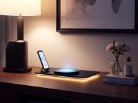 A luxurious wireless charging pad placed on a bedside table with a glowing smartphone.